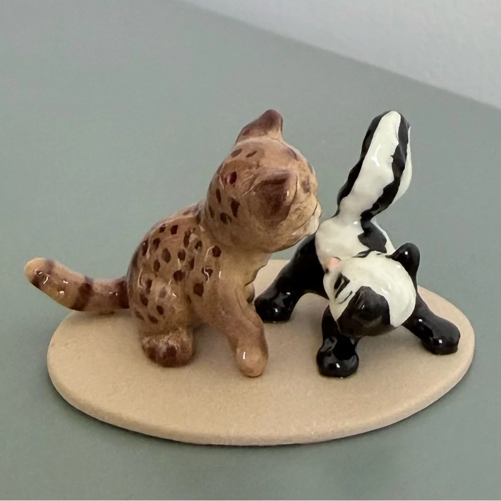Vintage retired Hagen Renaker bobcat and skunk babies on base